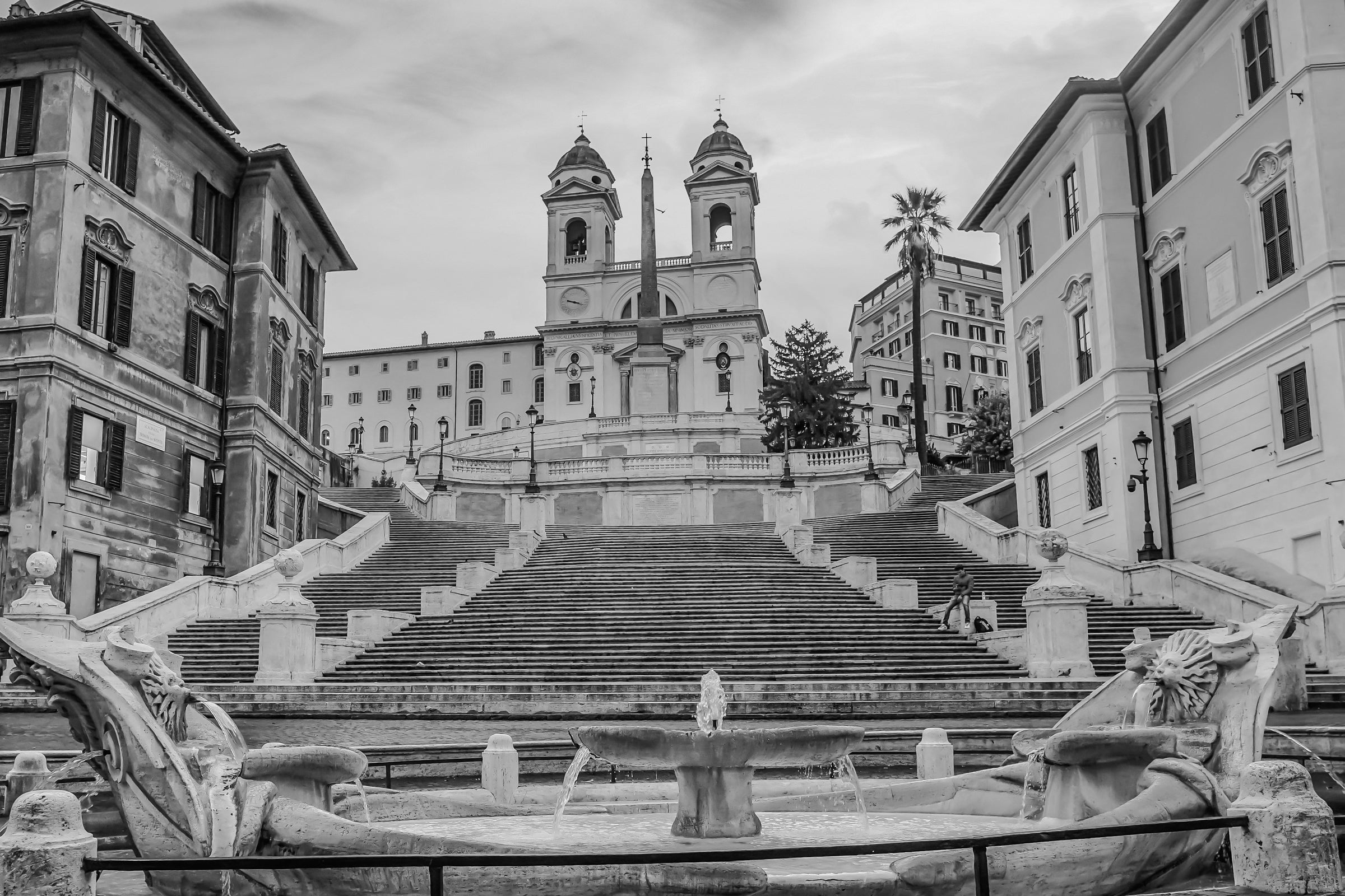 Schwarz-weiß Aufnahme der Spanischen Treppe in Rom mit barocker Kirche im Hintergrund und Barockbrunnen im Vordergrund