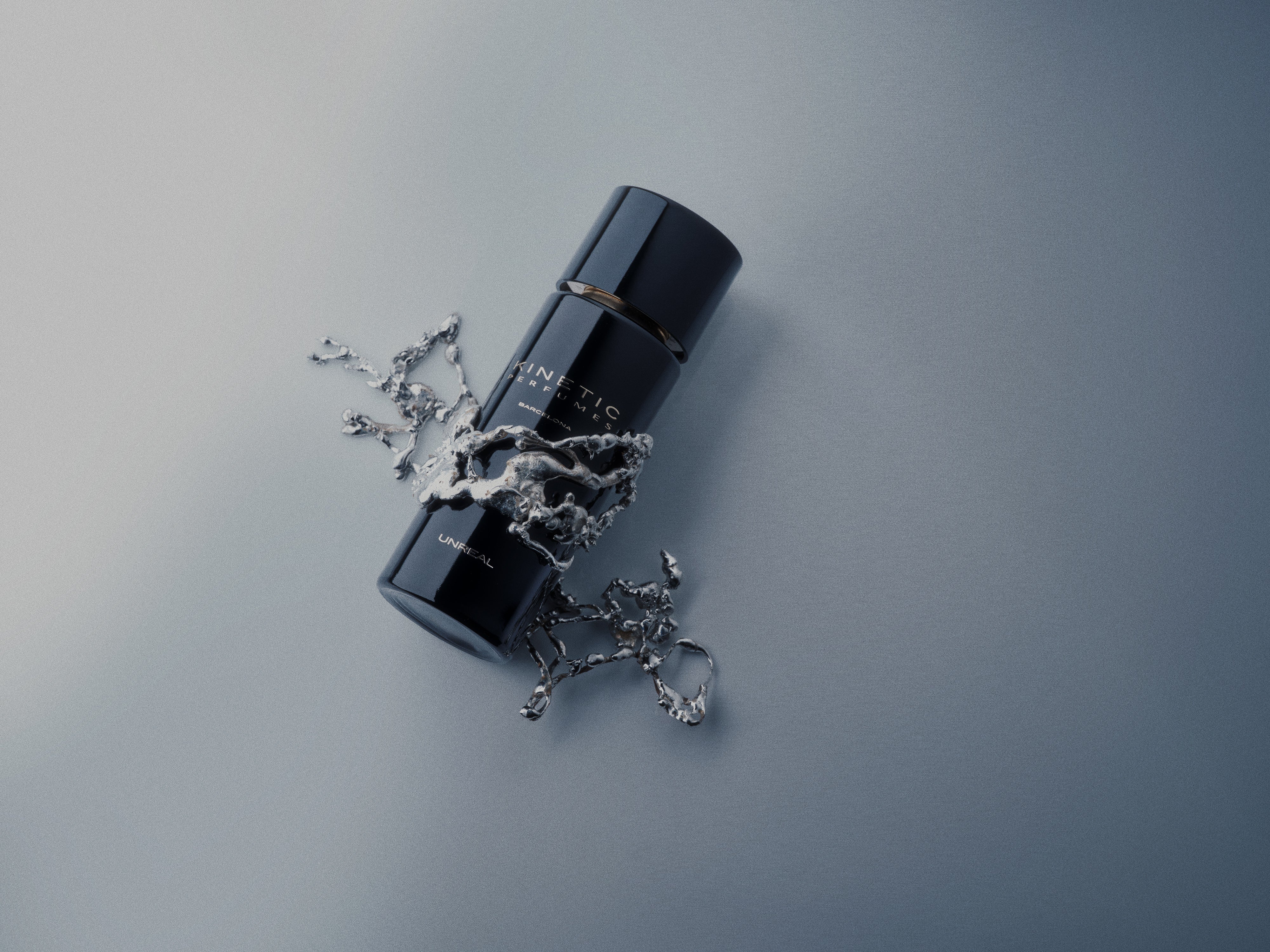 Dunkler Parfumflakon Unreal von Kinetic mit metallischem Ring auf blau-grauem Hintergrund, dekoriert mit silbernen ornamentalen Metallelementen