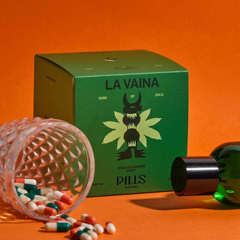 Grüne Parfumverpackung La Vaina von Pills mit abstraktem Cannabis-Motiv, umgeben von umgestürztem Glas mit bunten Kapseln mit orangefarbenem Hintergrund