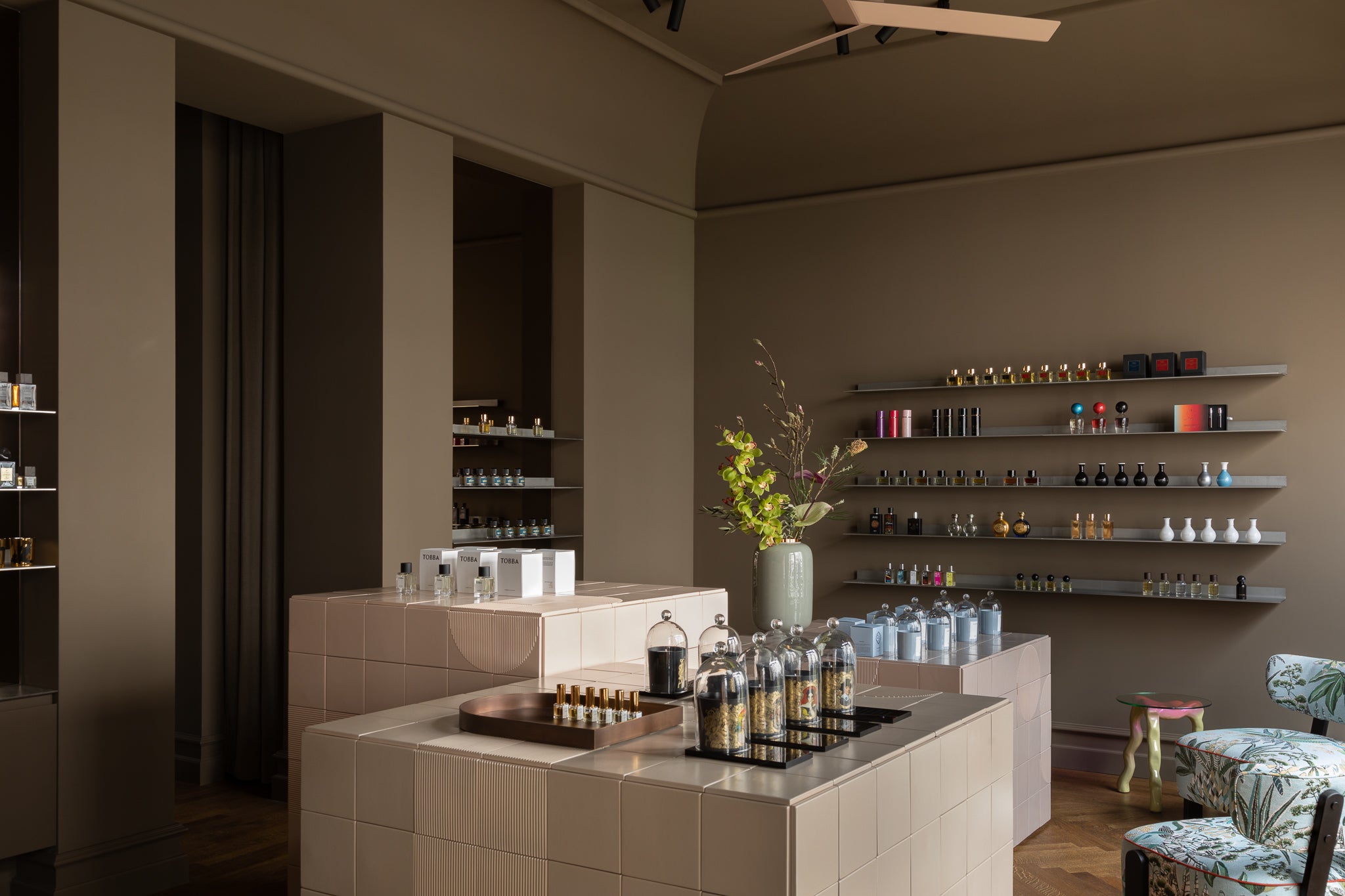 atmosphärische Innenansicht der Parfümerie 15West mit WandRegalen voller Parfumflakons, hellem Interieur, Glasglocken und Blumenarrangement auf der Verkaufstheke